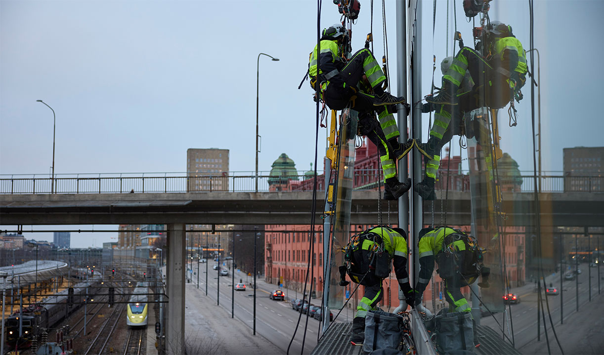 Men in high viz on side of building