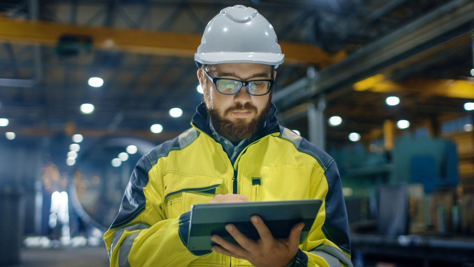 Man in hard hat looking at tablet