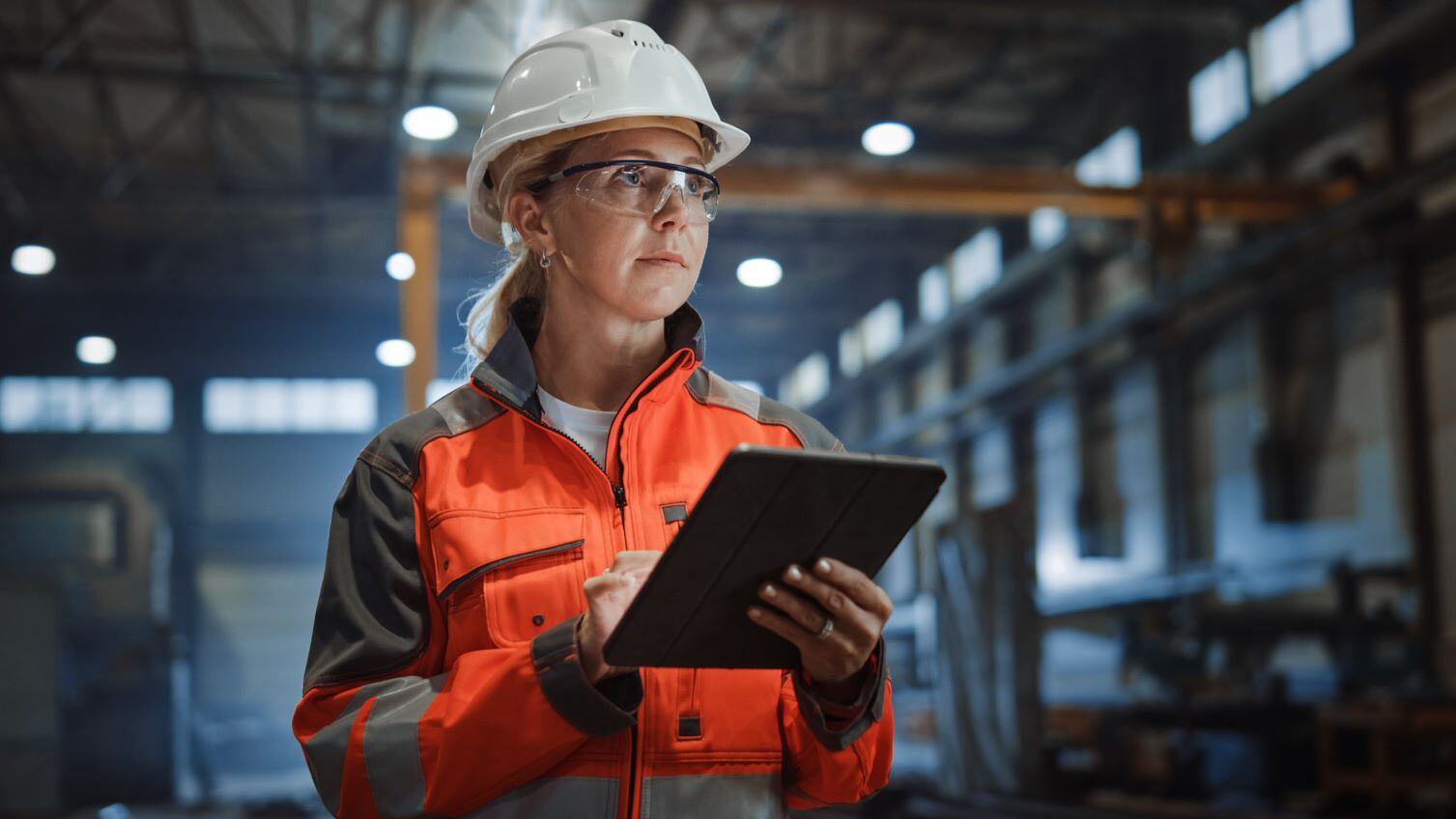 woman in hard hat holding tablet